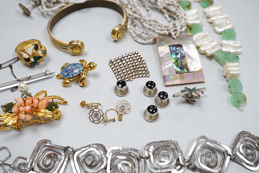 A collection of costume jewels, comprising: a floral coral and nephrite brooch; a composite opal triplet brooch designed as a turtle; a textured gilt metal ring set with hardstone fragments; a cultured pearl and chrysopr